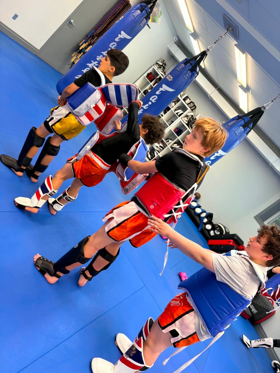 Kids working the bags in a Muay Thai class